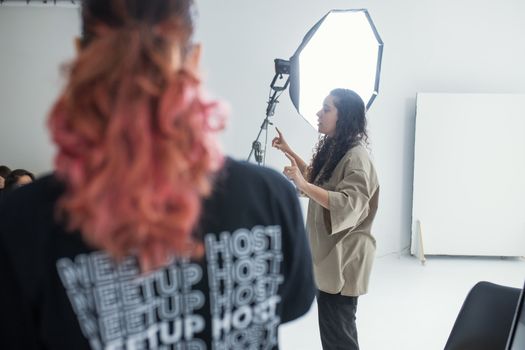 Photographer instructing during a professional indoor photography session with studio lighting.