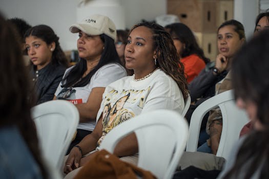 A diverse group of adults attentively listening during an indoor workshop.
