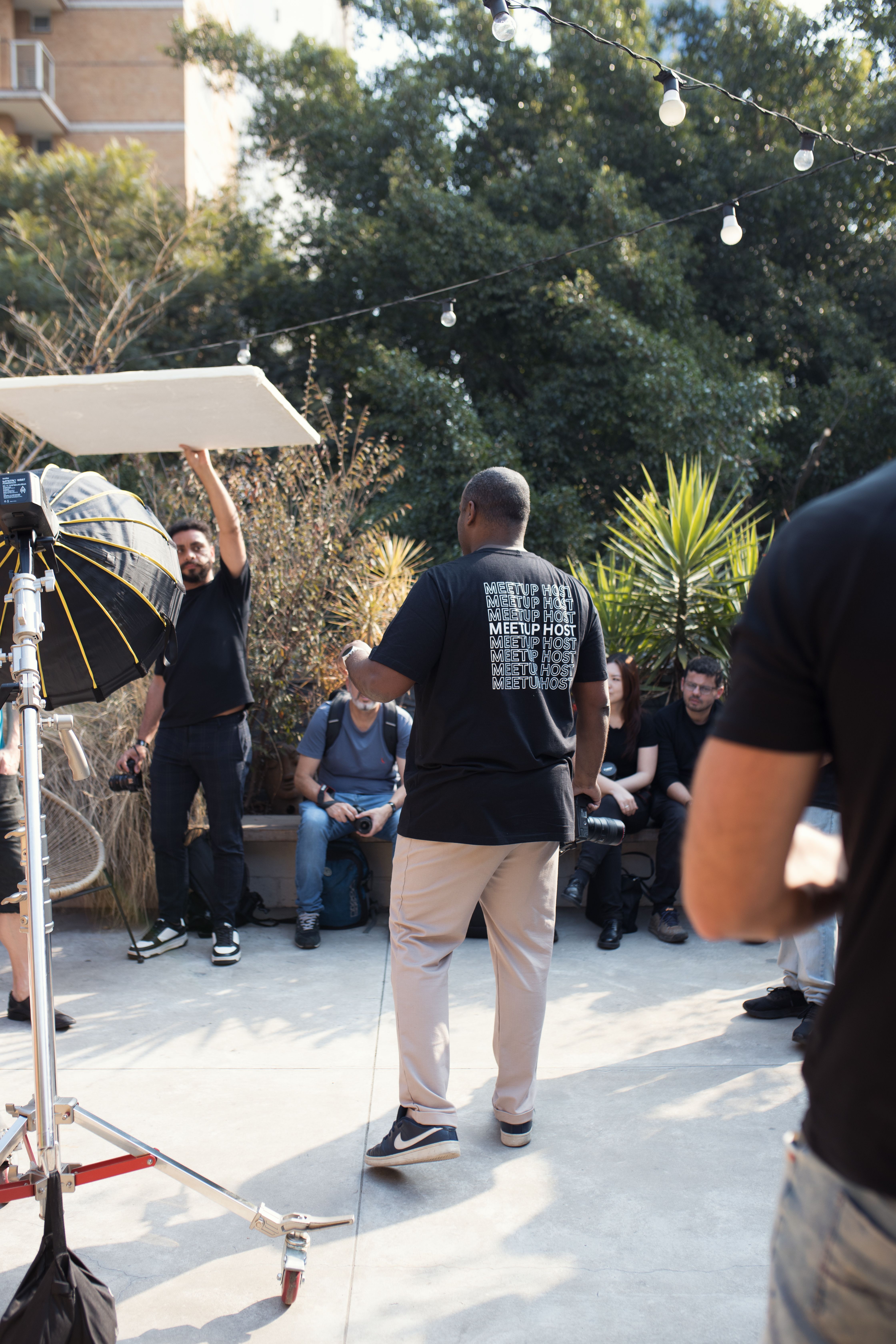 A diverse group of people attending an outdoor photography workshop with professional equipment.