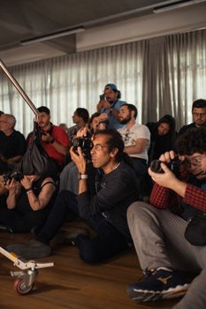 Group of photographers capturing moments at an indoor event, focusing on candid shots.