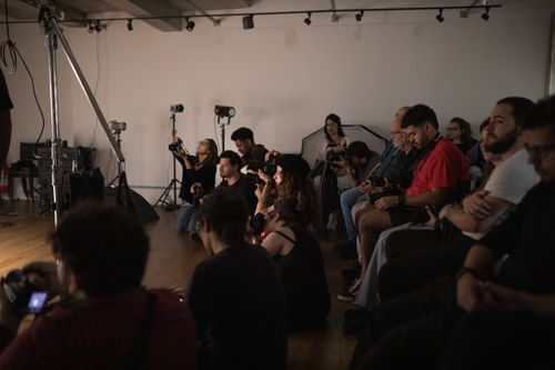 Free A group of photographers attentively engaged in a photography workshop indoors. Stock Photo