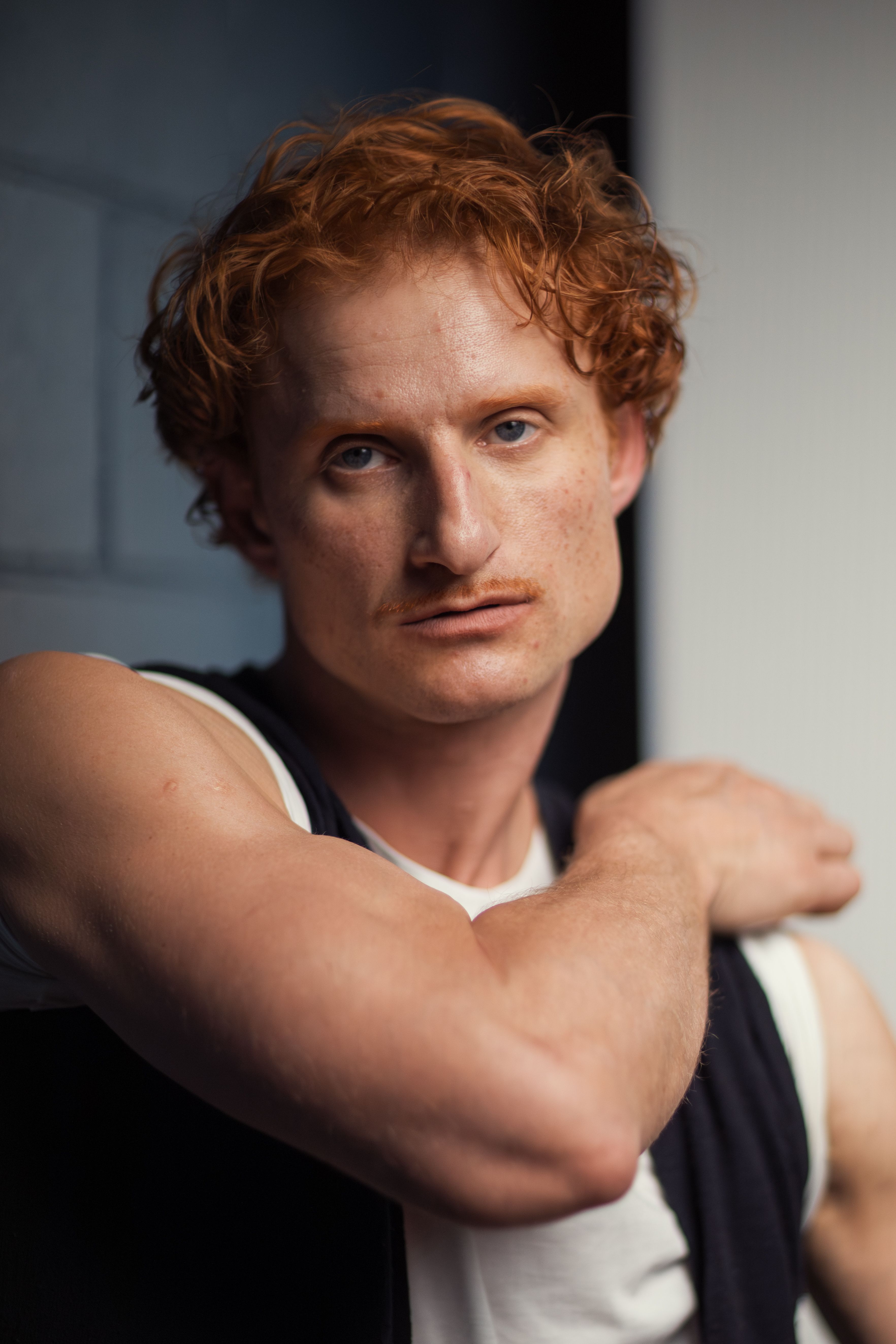Close-up portrait of a red-haired man with a penetrating gaze, showcasing an expressive look.