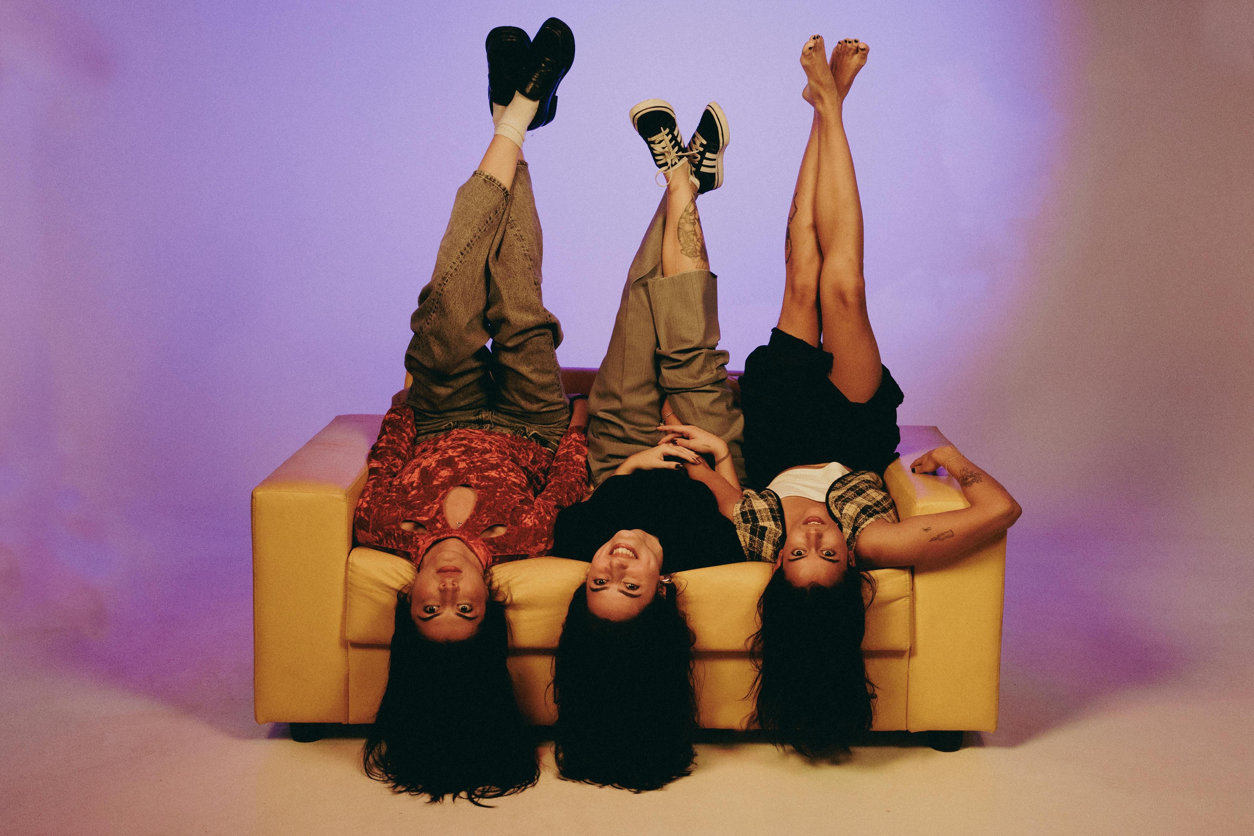 Playful Friends Hanging Upside Down on Couch