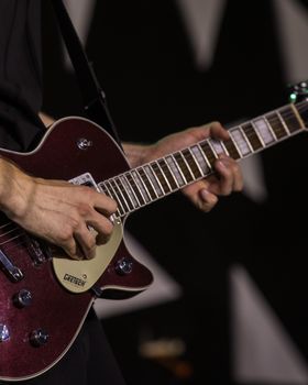 Musician passionately plays a Gretsch electric guitar during a live performance.. musician, passionately, plays