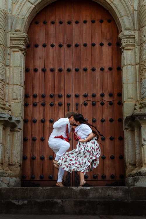 Free A lively depiction of traditional Mexican dance in front of a historic church in Oaxaca. Stock Photo