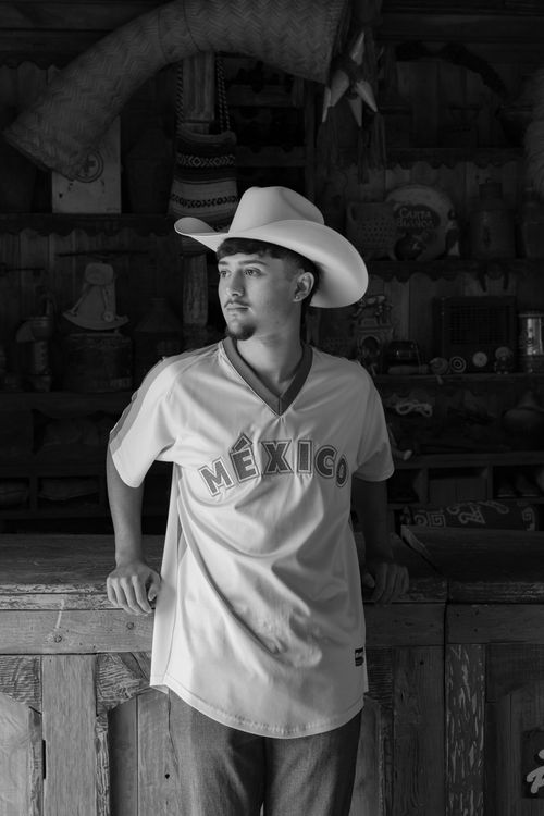 Free A man in a cowboy hat and Mexico jersey poses indoors. Black and white. Stock Photo