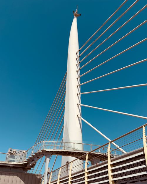Free Sleek modern cable-stayed bridge against a bright blue sky, showcasing architectural beauty. Stock Photo