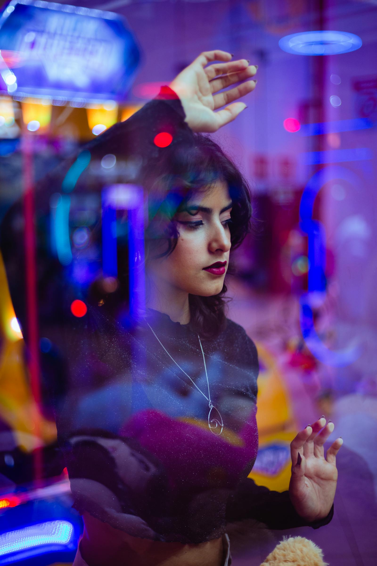Portrait with neon arcade reflections and candy-colored lights in a Y2K photography style