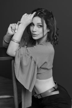 Black and white portrait of a young woman in a studio, capturing elegance and confidence.