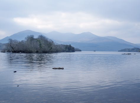 Tranquil lake and mountain scene in Killarney National Park, Ireland under a cloudy sky.