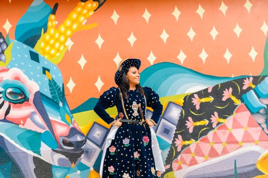 Colorful mural with a woman in traditional Oaxacan attire against a vibrant alebrije background.