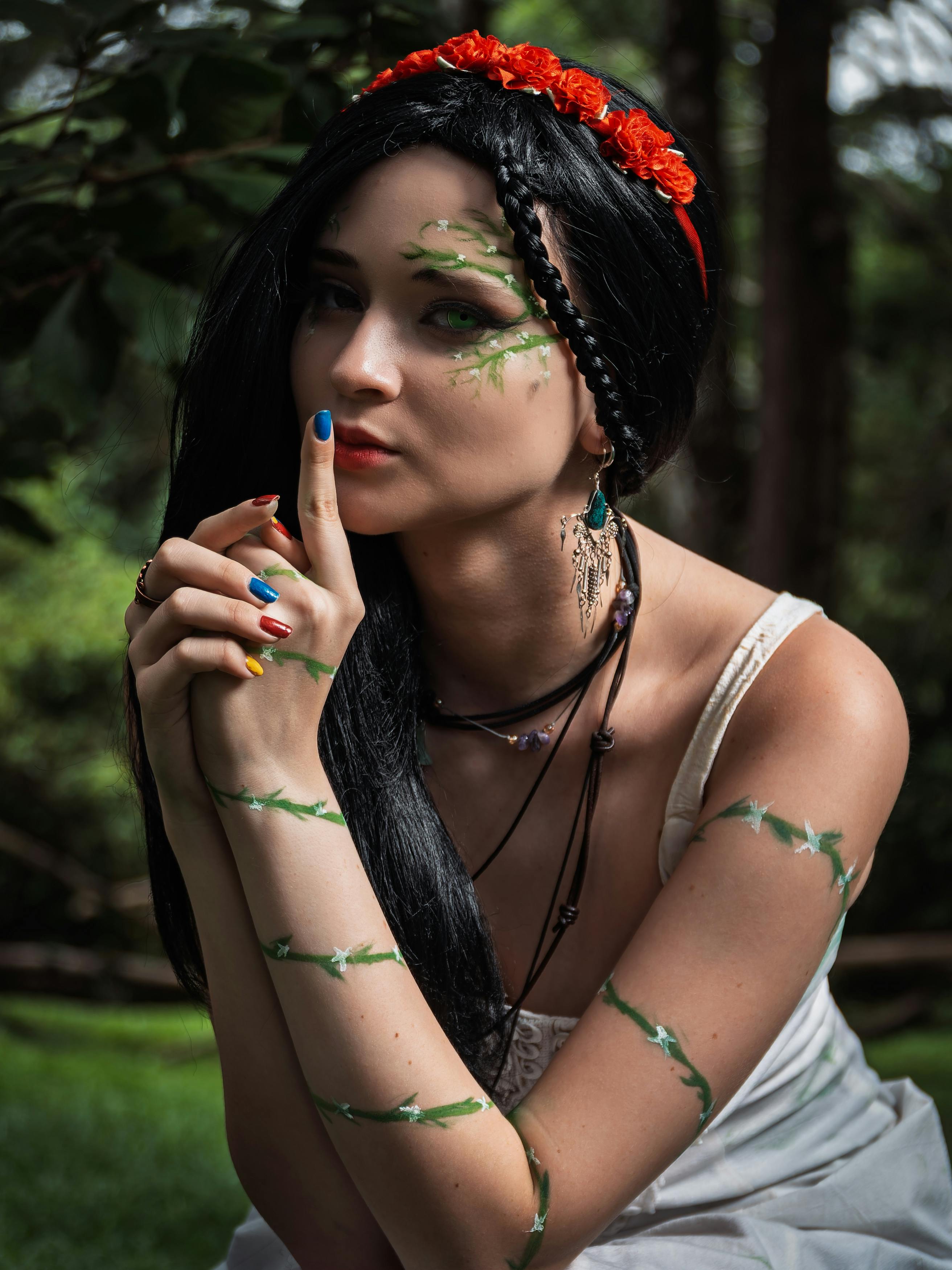 Mysterious woman with floral makeup posing in a lush forest in Costa Rica.