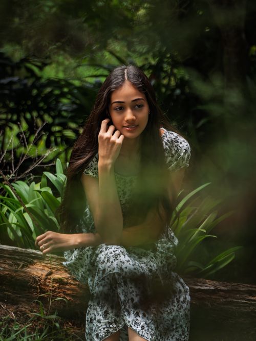 Free Captivating portrait of a young woman sitting in a vibrant green forest in Alajuela, Costa Rica. Stock Photo