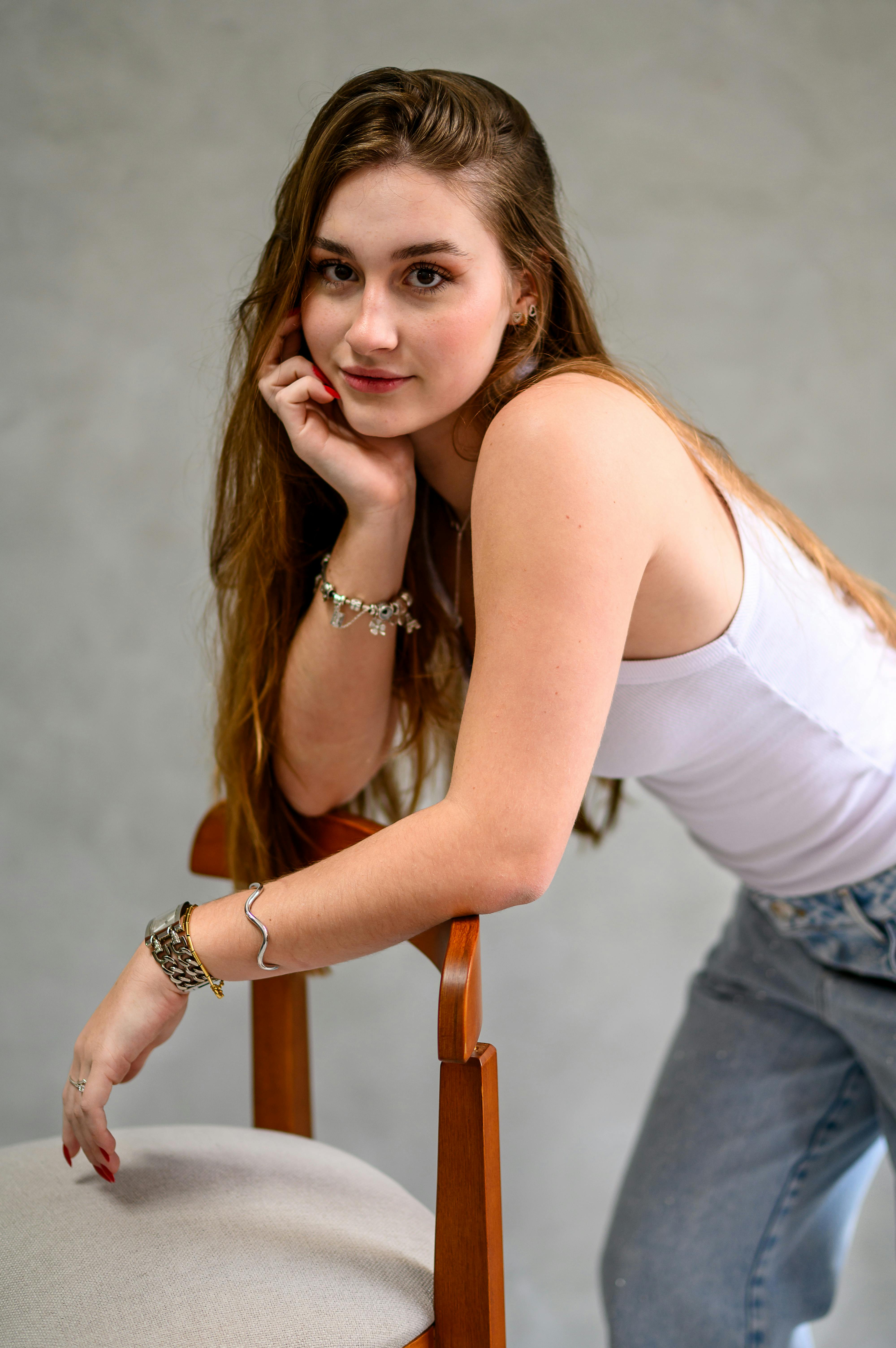 Charming portrait of a young woman in casual attire posing confidently indoors