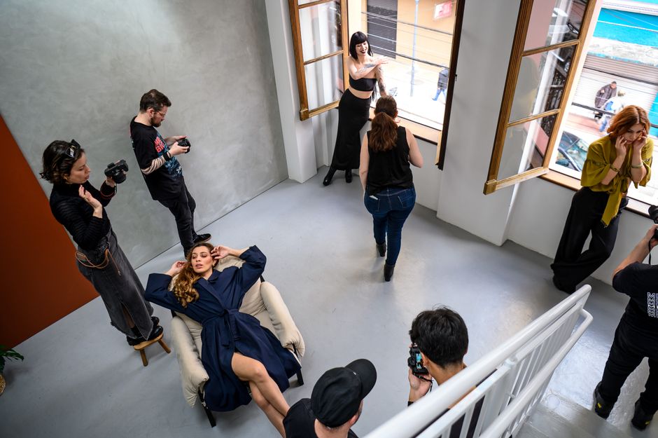 A dynamic fashion photoshoot capturing model poses and photographers at work in a modern studio in Curitiba.