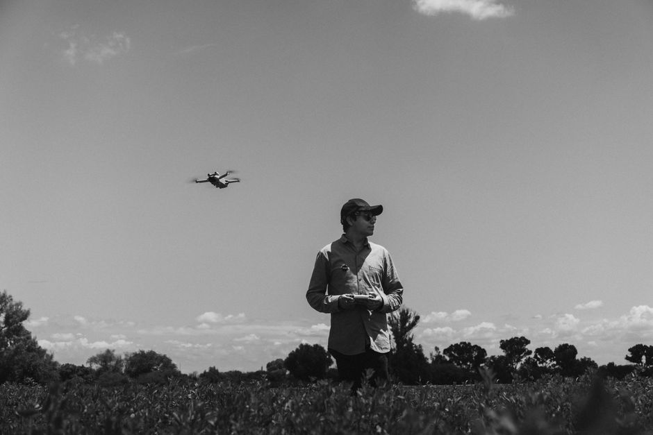 A person operates a drone in a peaceful rural landscape in Purísima de Cubos, México.