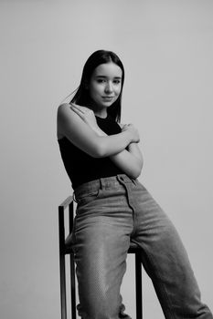 Artistic black and white portrait of a young woman posing confidently indoors.