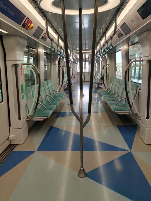 Free A clean, modern subway car interior with teal seats and geometric floor pattern. Stock Photo