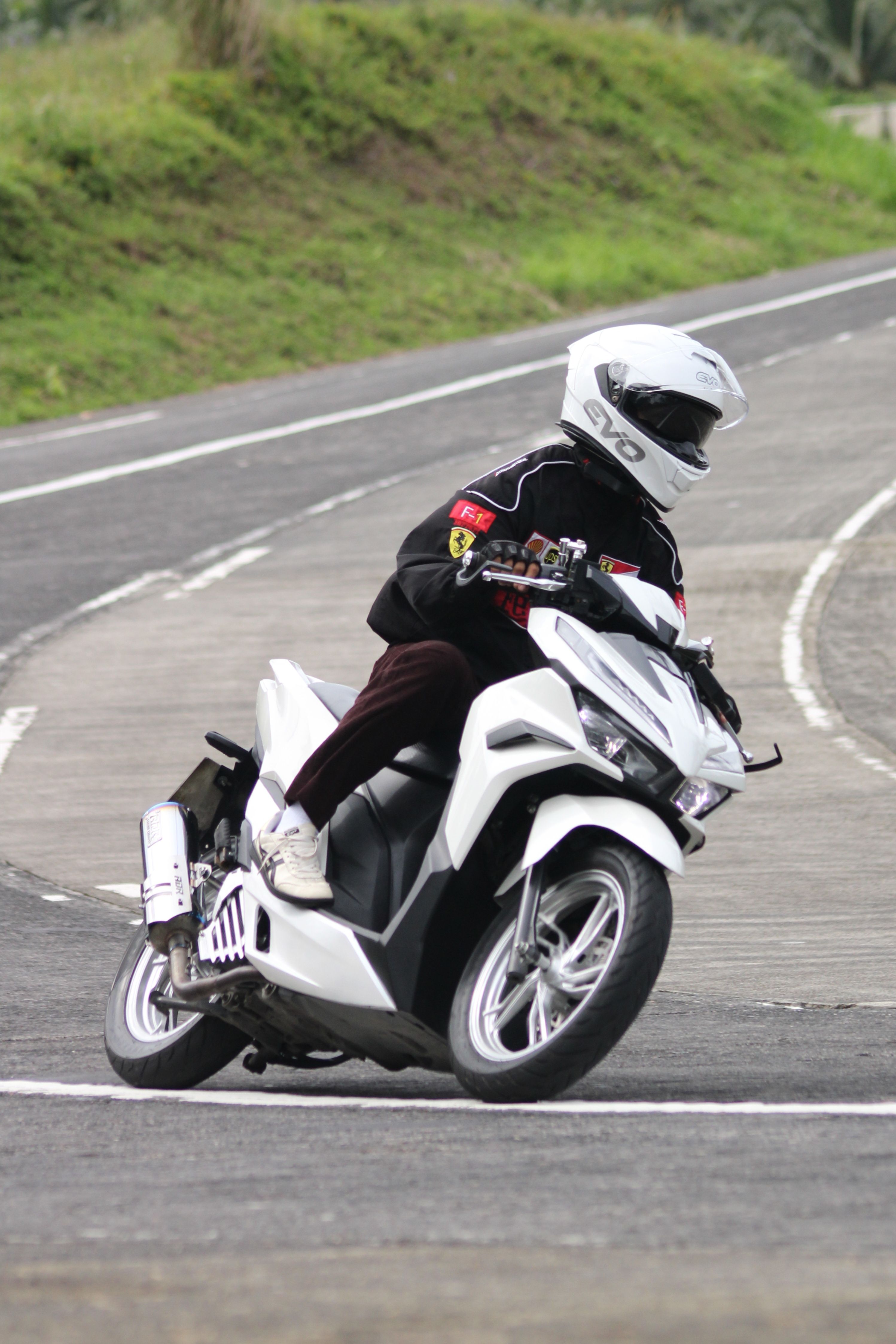 A motorcyclist makes a sharp turn on an open road, showcasing riding skills.