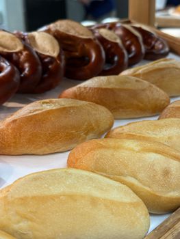 Close-up of diverse bread selection including pretzels and rolls.