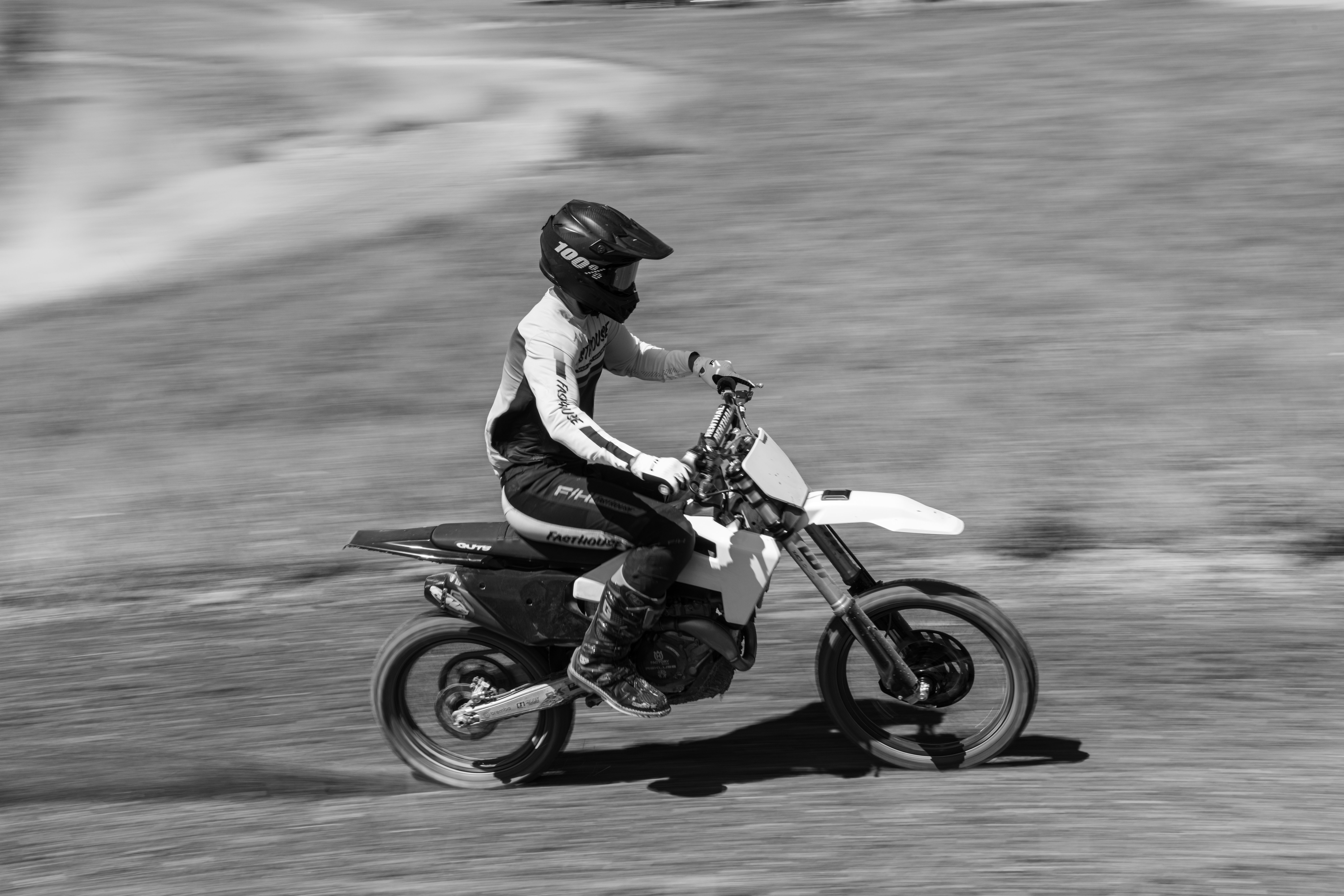 Black and white photo of a motocross rider racing on a dirt track in Pennsylvania.