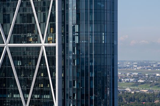 Close-up of a modern skyscraper's glass facade with a cityscape in the background.