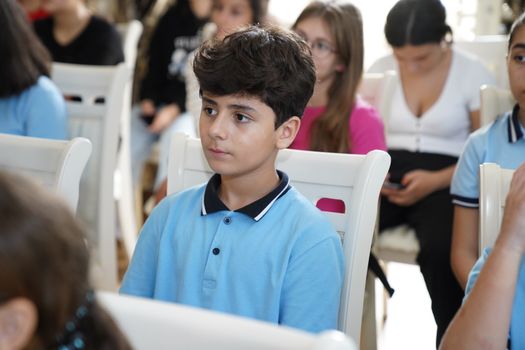 A student in a blue shirt attentively listens during a classroom session.