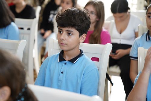 Free A student in a blue shirt attentively listens during a classroom session. Stock Photo