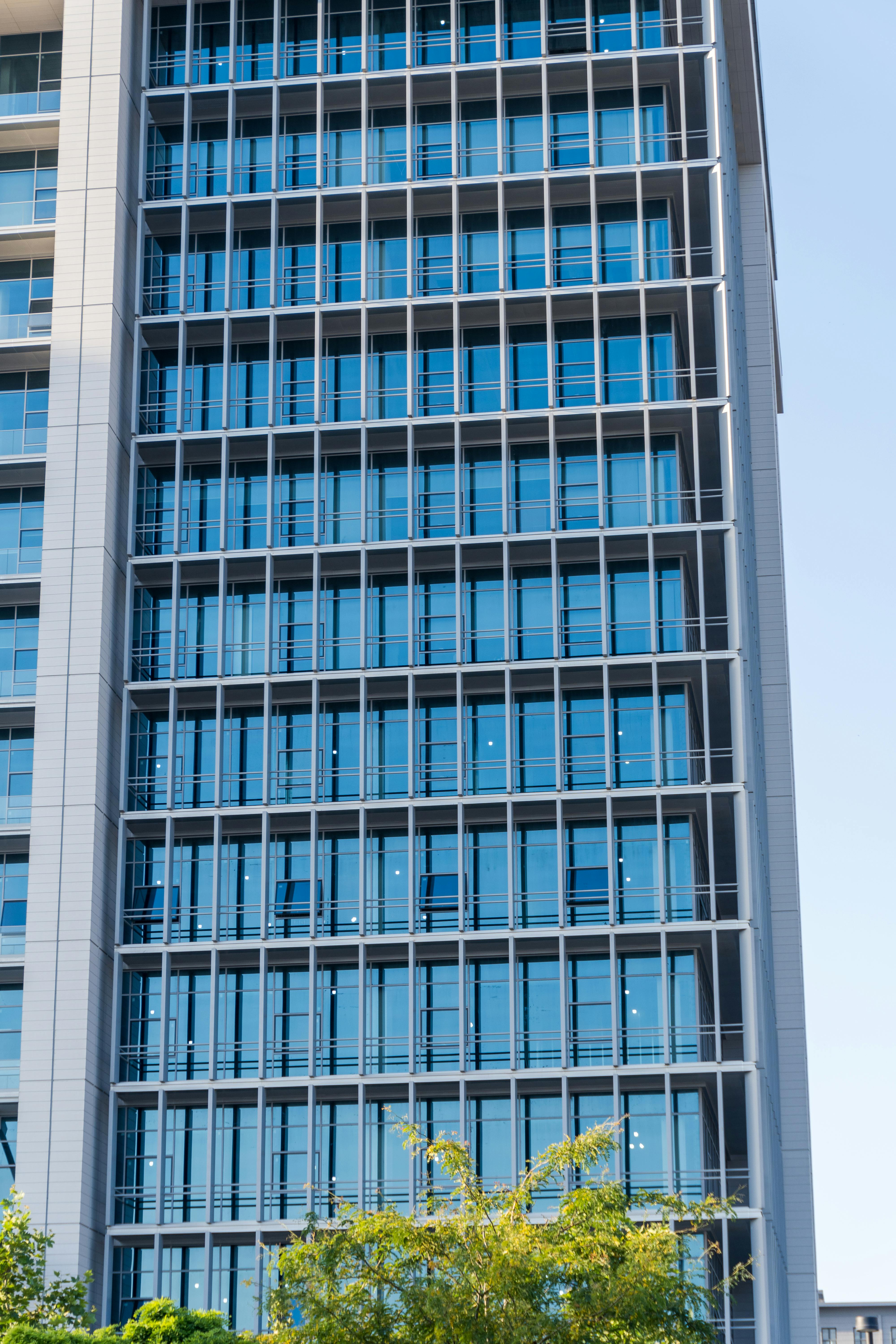 Close-up of a modern high-rise office building with glass facade reflecting the sky.