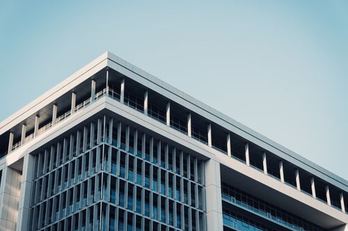 Free Contemporary office building with a futuristic glass facade reflecting the sky. Stock Photo