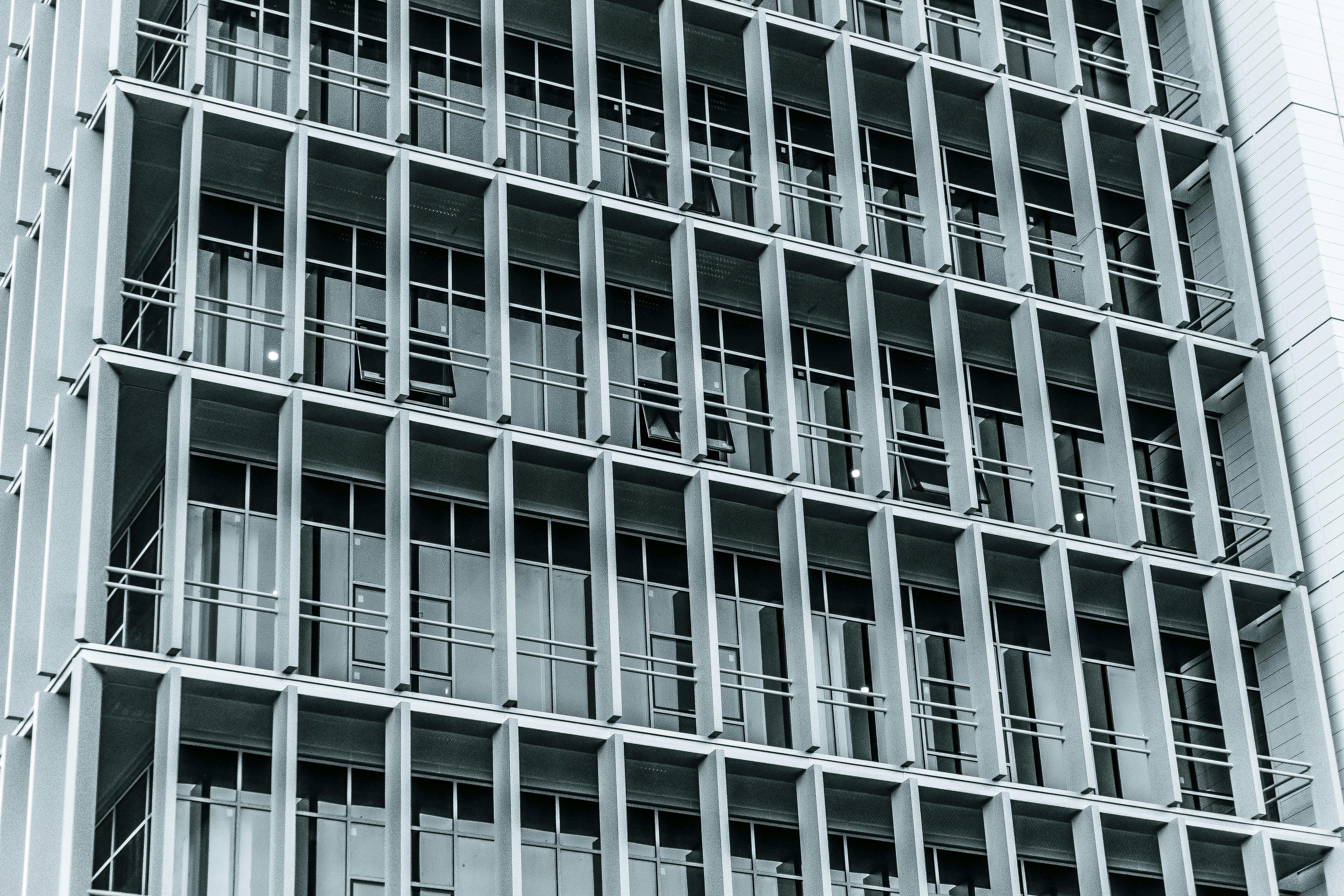 免费 现代高层建筑立面的特写，展示了窗户和阳台的网格图案。 素材图片