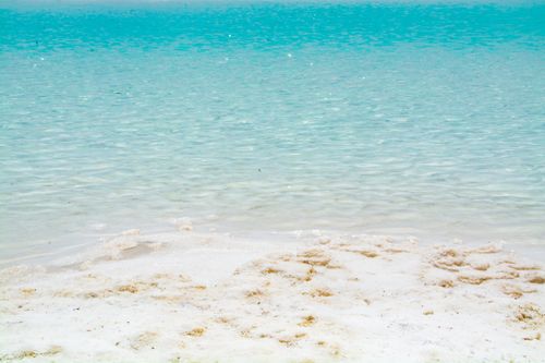 Free Peaceful beach scene with clear turquoise water and pristine white sand. Stock Photo