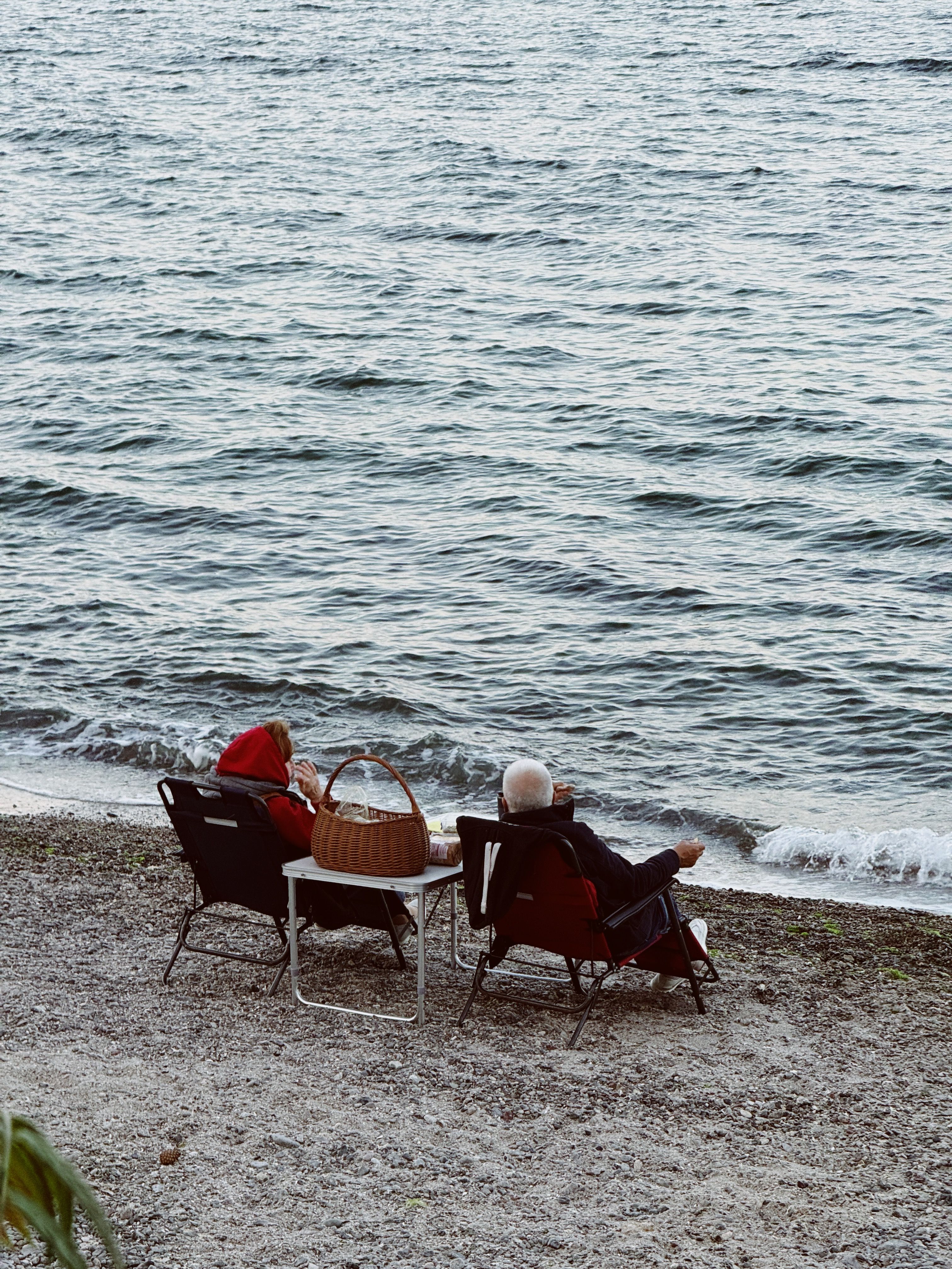 Free Elderly couple enjoying a peaceful picnic by the lake, capturing love in nature. Stock Photo