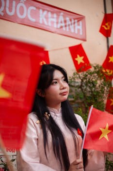 Young woman in traditional dress celebrating Vietnamese National Day with flags.