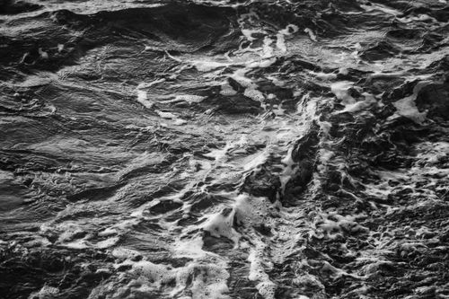 Free Monochrome image capturing the dynamic movement of ocean waves with foam. Stock Photo