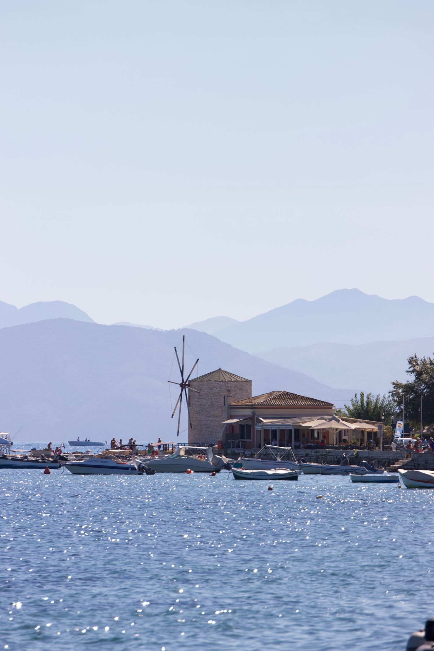 Harbour with a traditional windmill and mountains behind, Corfu, Greece