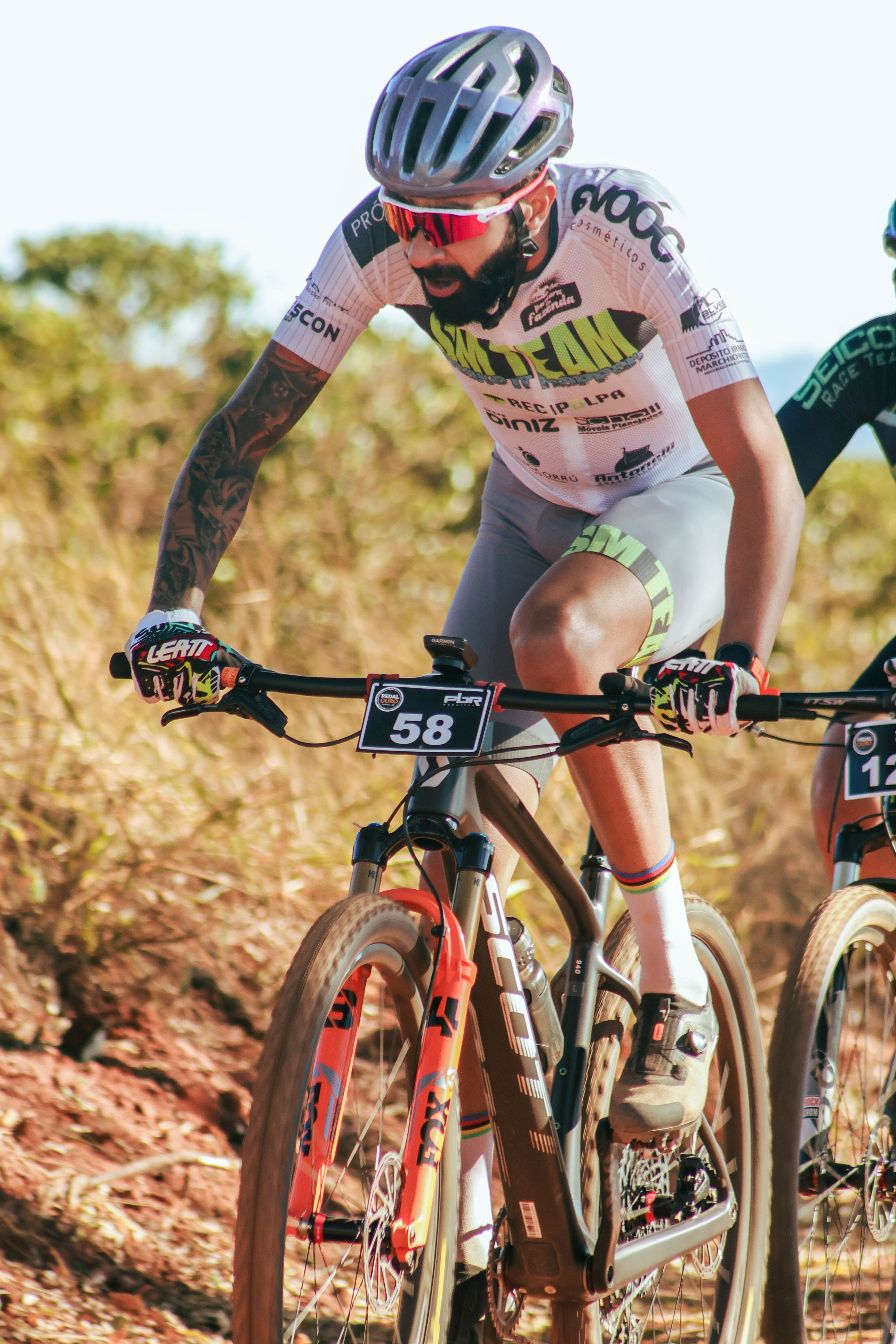 Competitive mountain biking race with cyclists on a rugged outdoor trail under bright daylight.