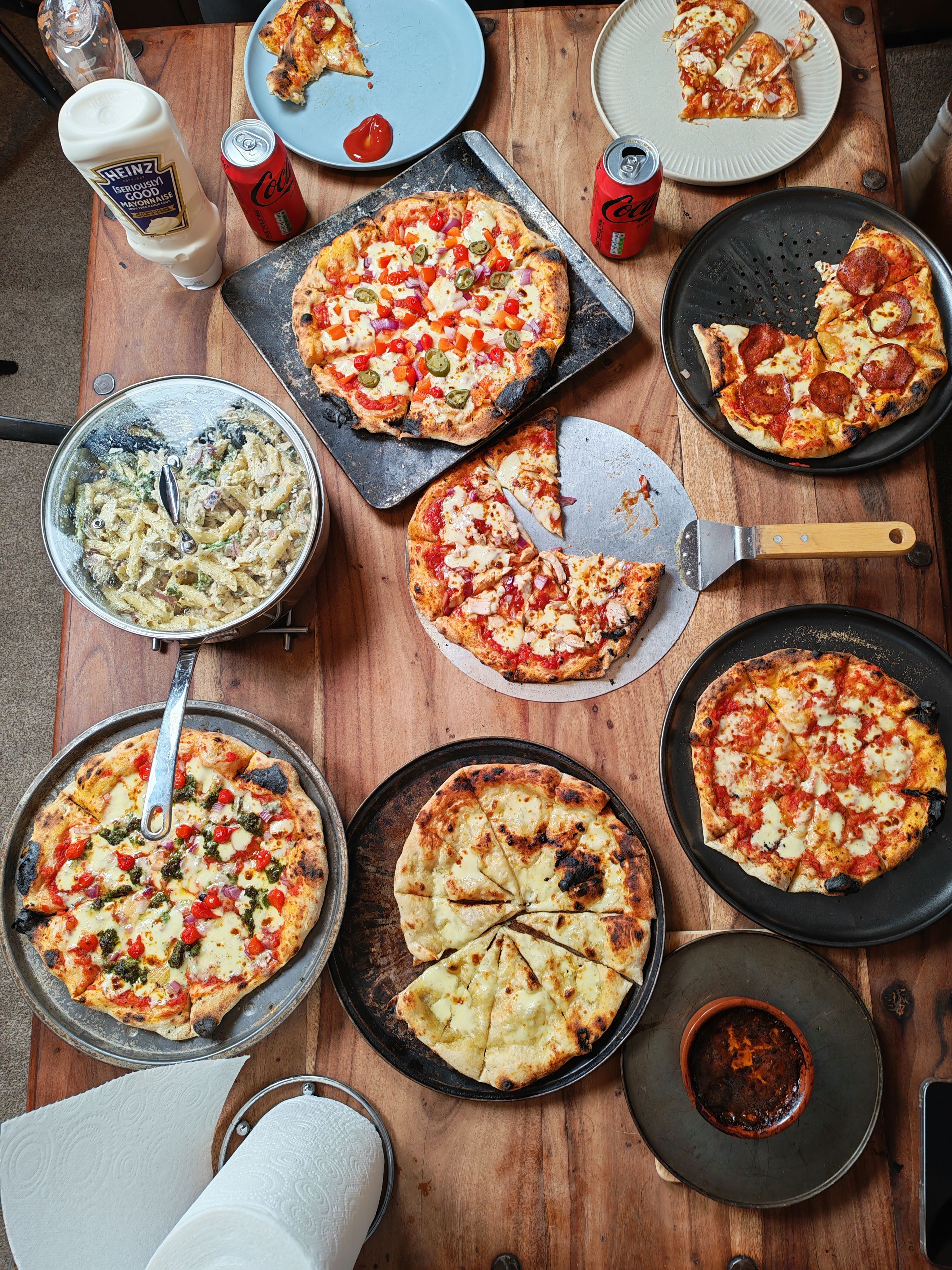 Top view of a table filled with various pizzas, pasta, and beverages, perfect for a feast.