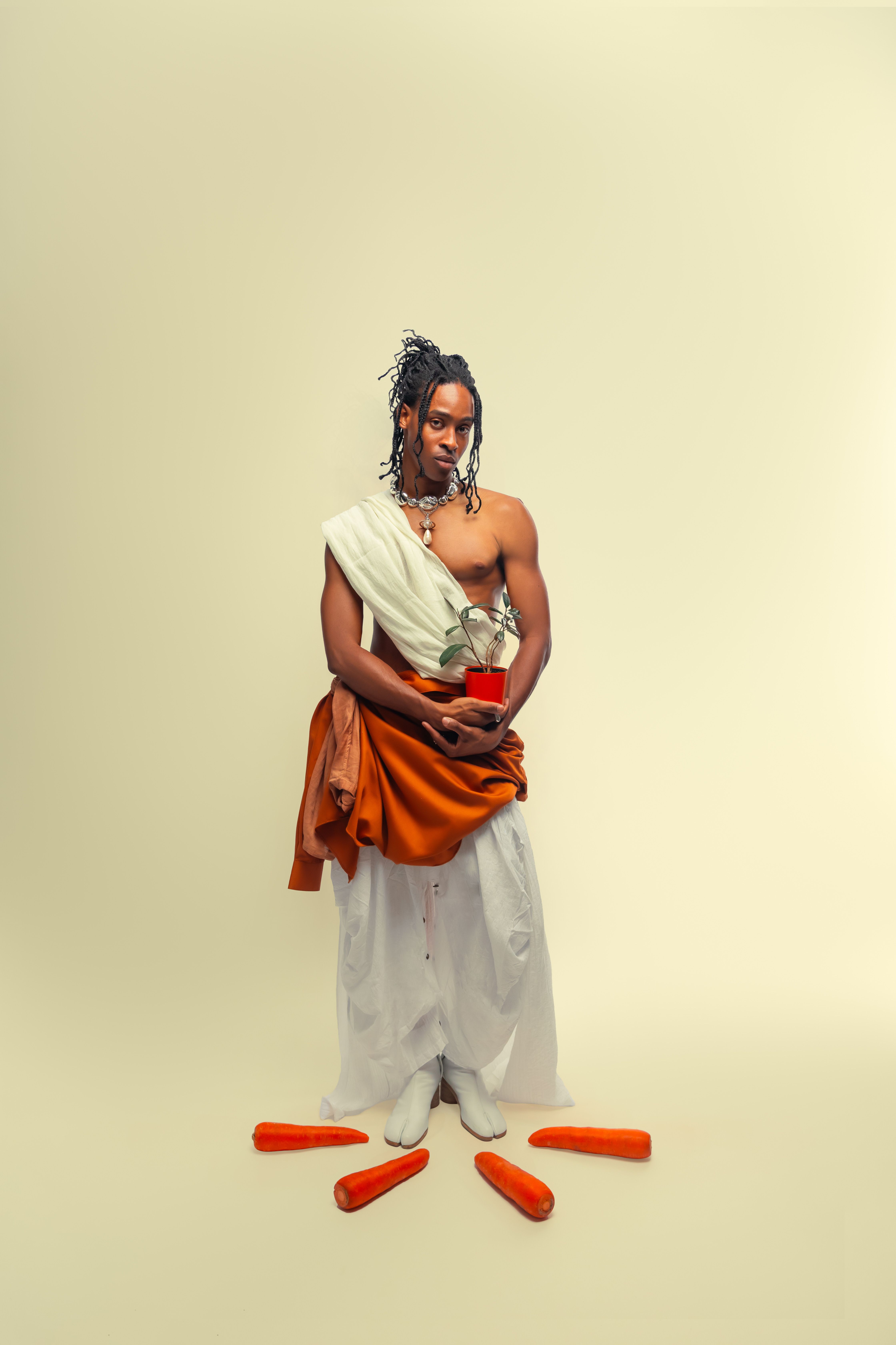 Artistic portrait of a person in traditional clothing with carrots.