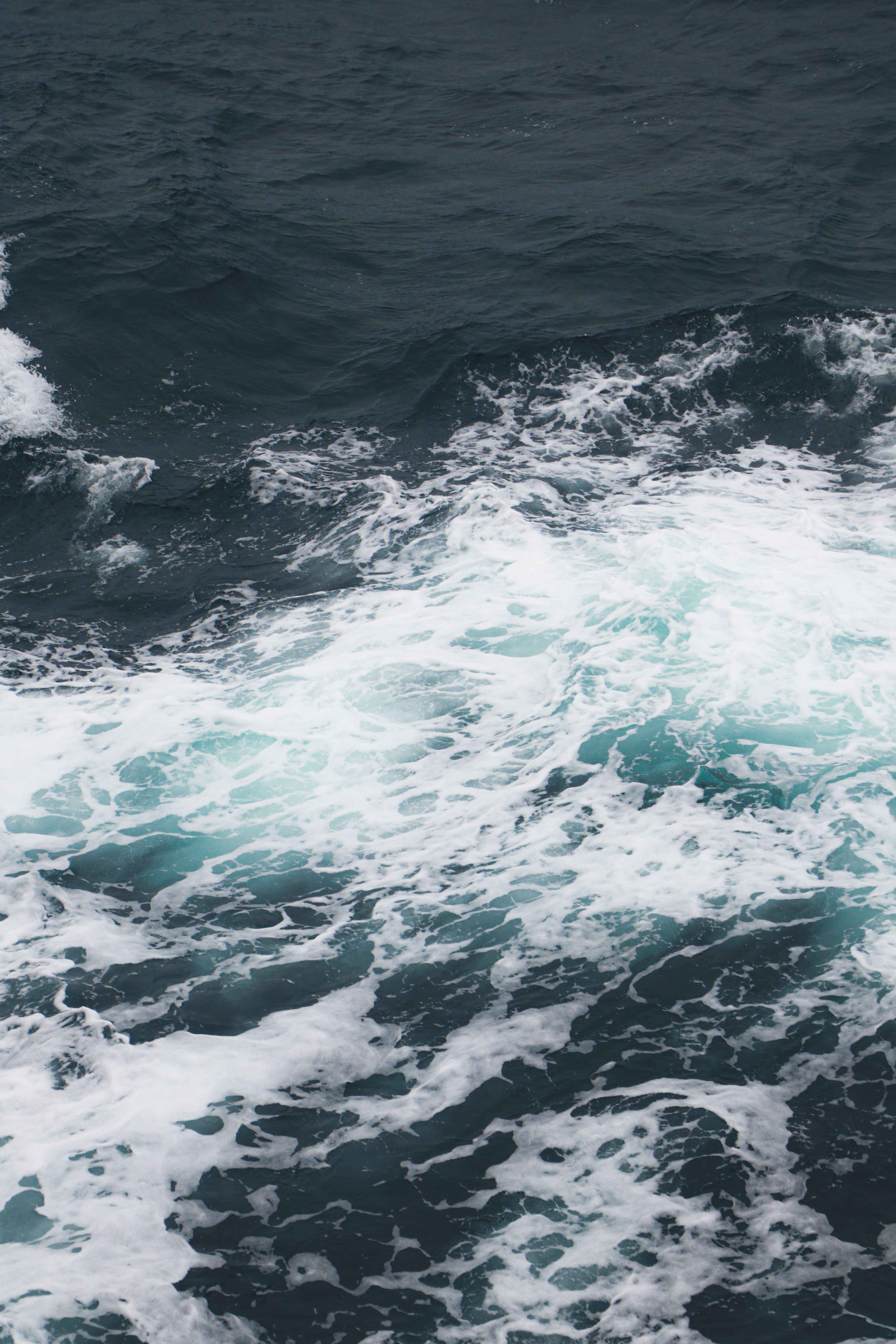 Captivating view of ocean waves crashing with white foam on the deep blue sea surface.