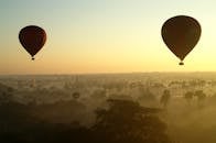 日出时，热气球漂浮在缅甸旧蒲甘的薄雾之上