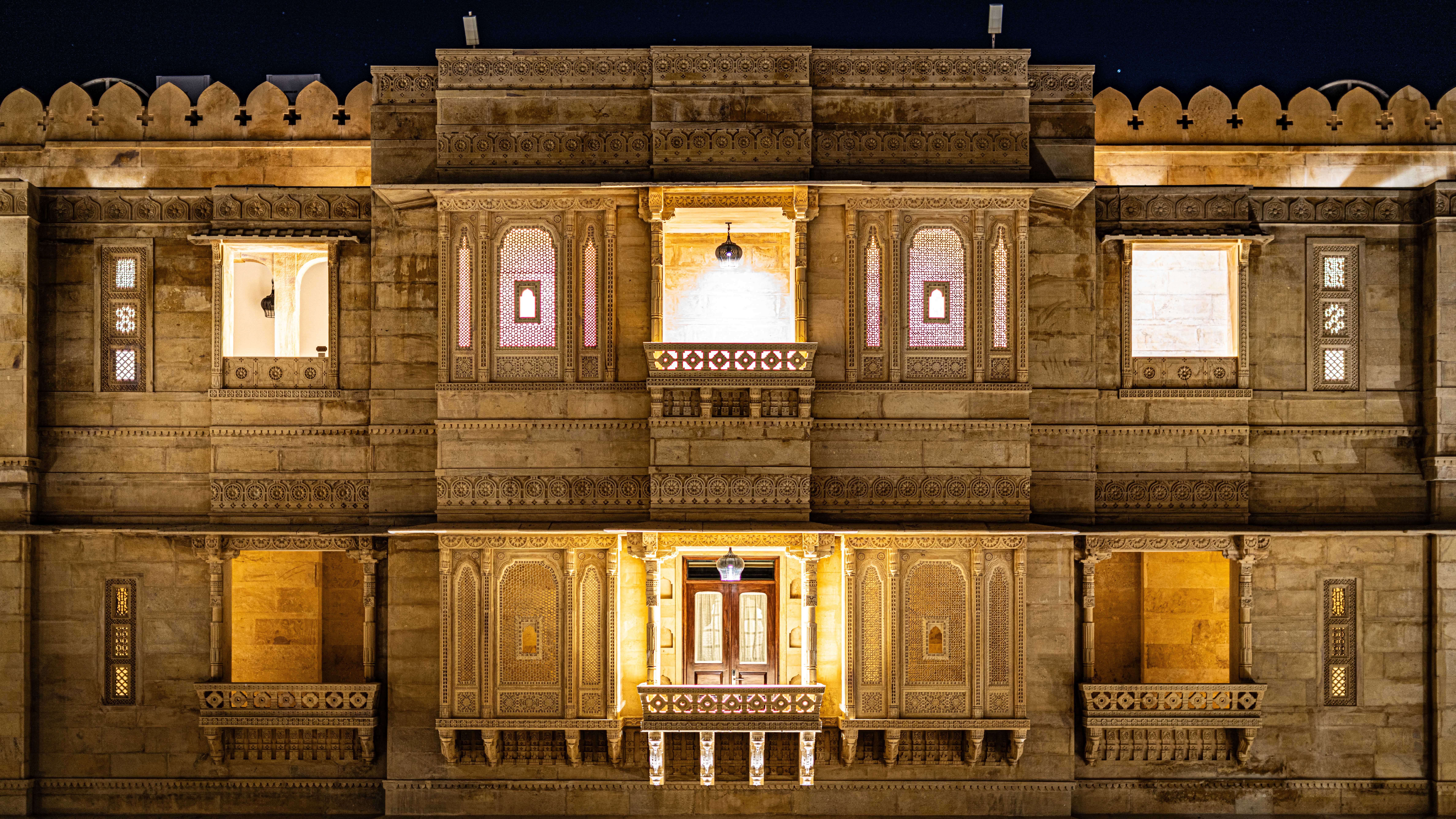 Captivating nighttime view of a beautifully illuminated ornate palace facade in Jaisalmer, Rajasthan, India.