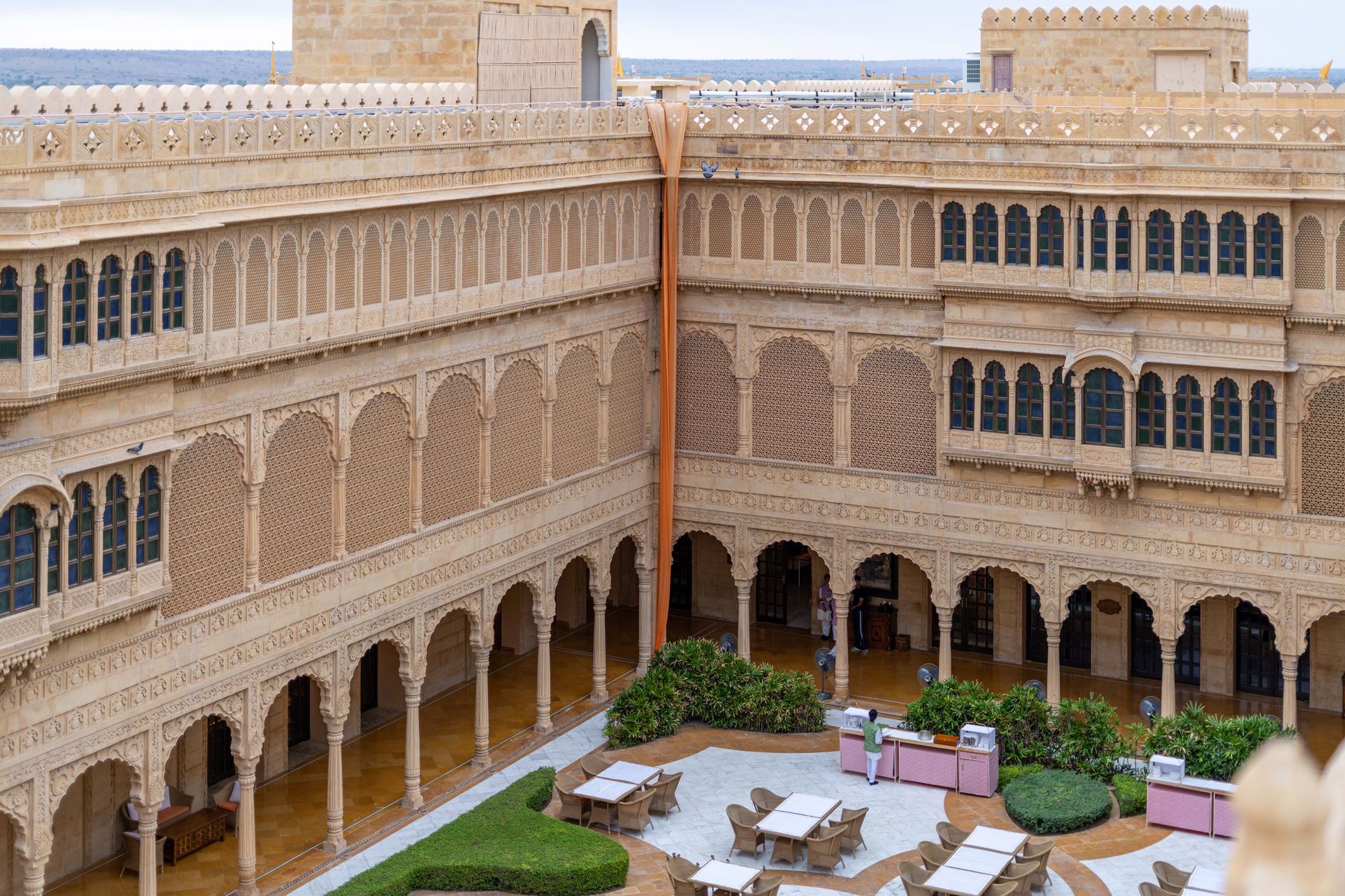 Explore the intricate sandstone architecture of a Jaisalmer heritage hotel courtyard.