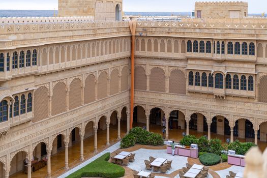 Explore the intricate sandstone architecture of a Jaisalmer heritage hotel courtyard.