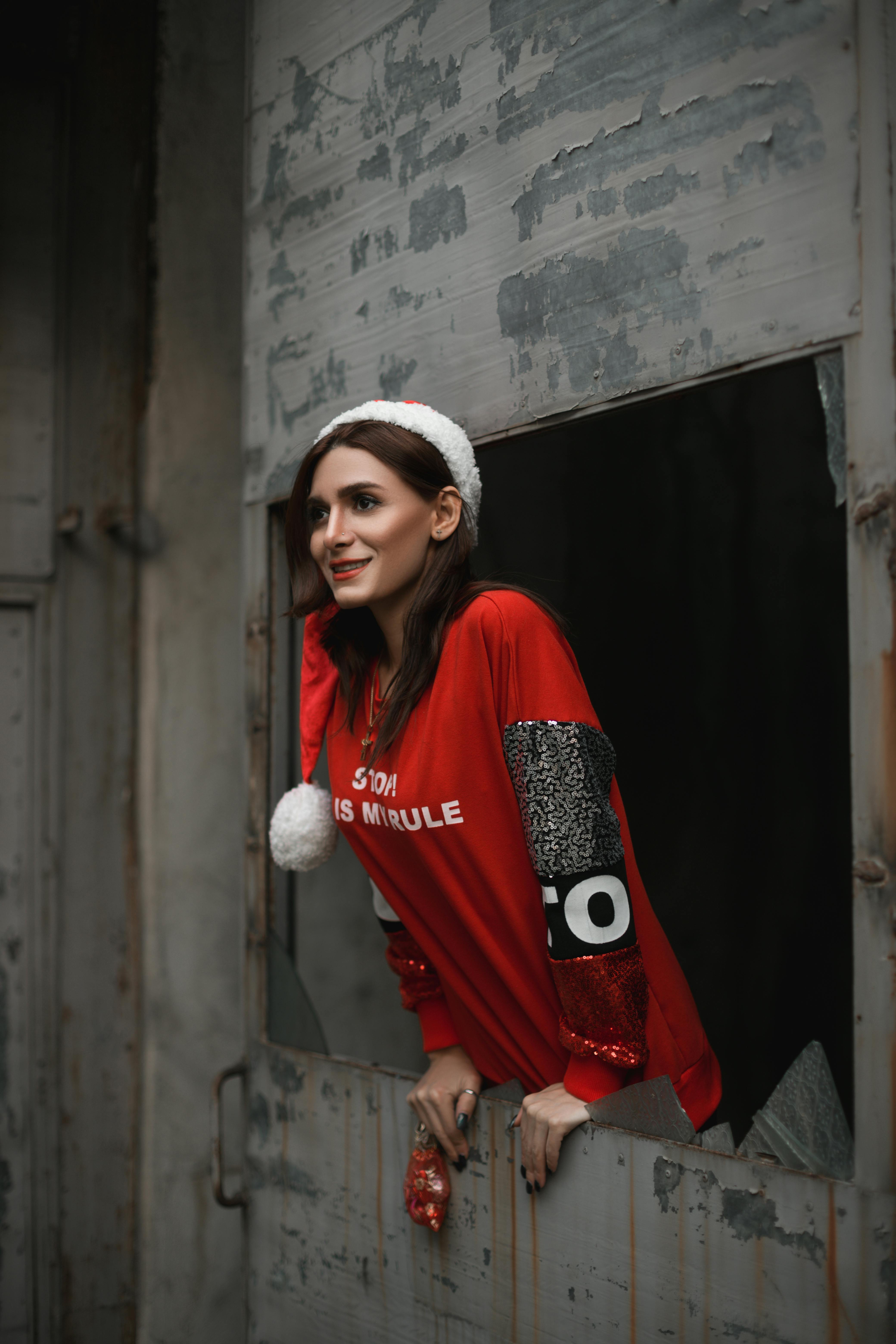 照片里，一位头戴圣诞帽、身穿红色毛衣的女子正兴高采烈地摆着姿势