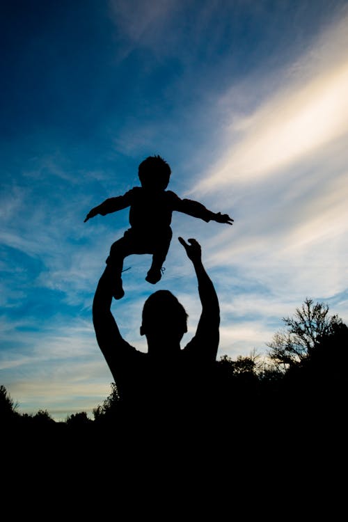 Silhouette of Man Throwing Baby