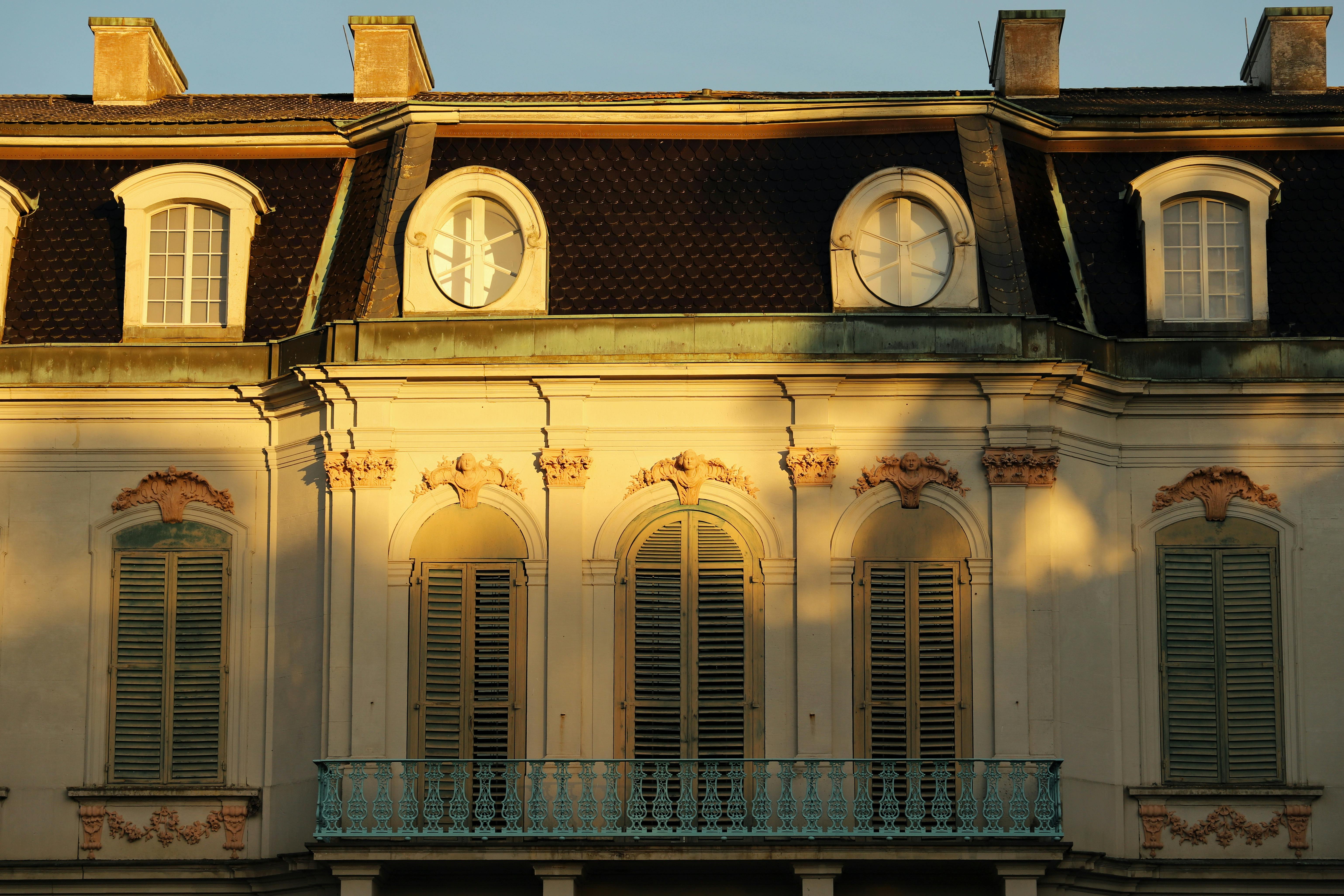 Elegant European architecture with sunlight casting shadows on a historic balcony facade in Kassel, Germany.