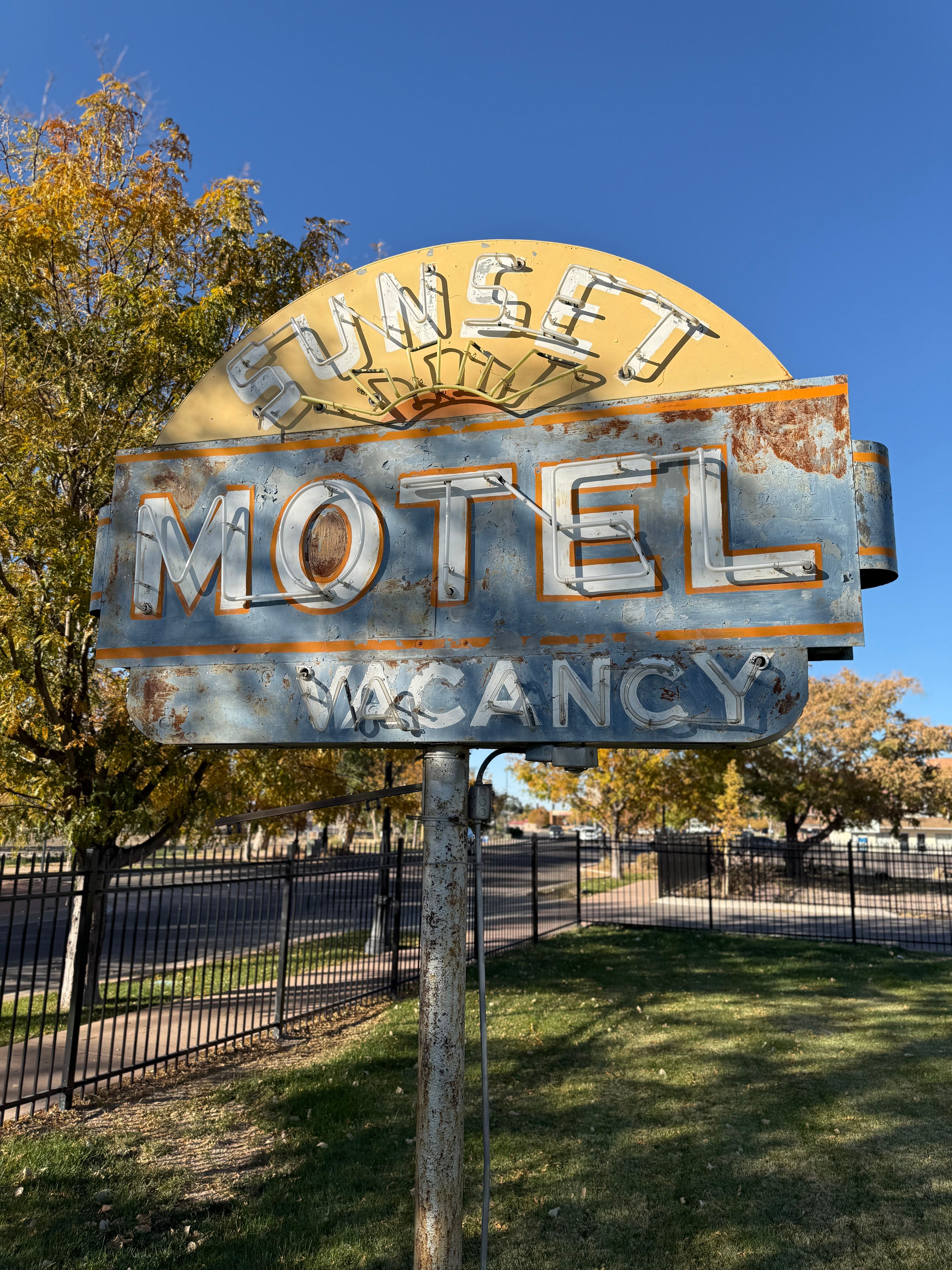 Rustic vintage motel sign with vacancy notice during the daytime.