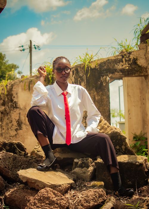 Free Confident person with red tie posing among ruins outdoors under a sunny sky. Stock Photo