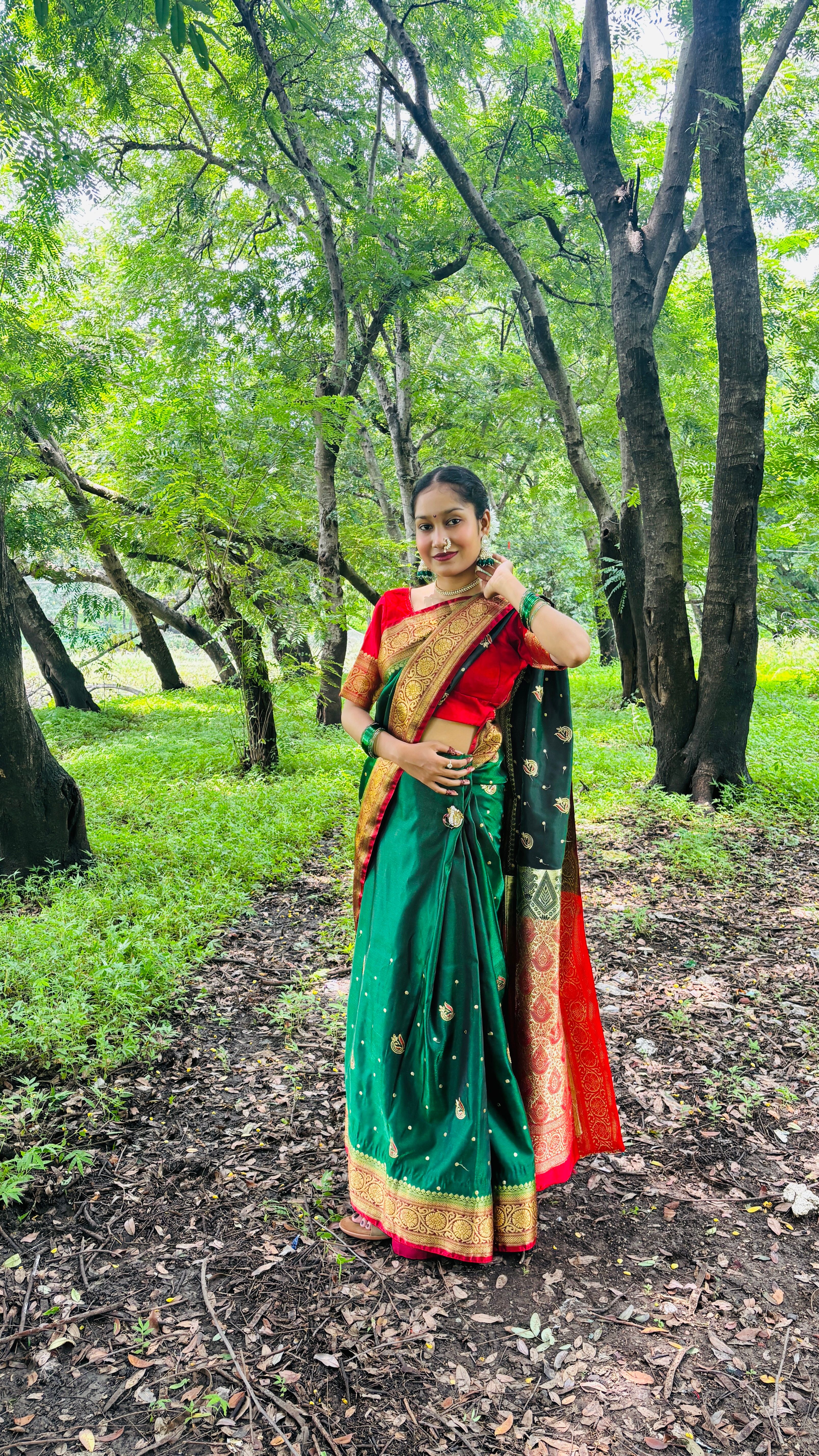 Smiling woman wearing a colorful saree in a verdant forest background, embracing nature.